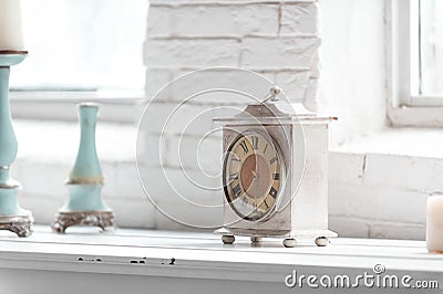 Light shabby chic interior fragment with clock and candlesticks Stock Photo