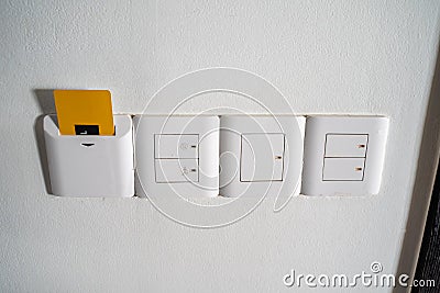 Light switches and power outlets typical of an Asian Hotel. Room key is in the slot to provide power to the room Stock Photo