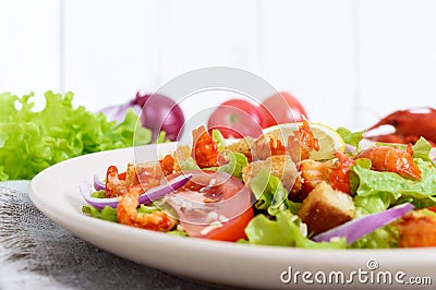 Light tasty salad with meat of a cancer, shrimps, lettuce, garlic croutons, tomatoes Stock Photo