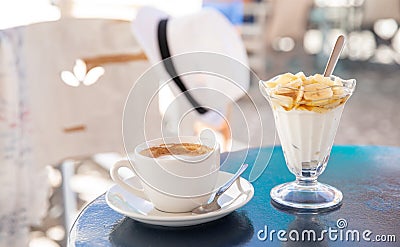 Light and tasty summer holidays breakfast cap of coffee cappuccino and yogurt with sliced banana, pear topped with honey in the Stock Photo