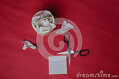 Light trash bin on red background. Closeup of crumpled sheets of paper and scissors. Concept of recycling of paper waste Stock Photo