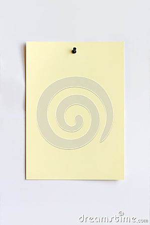 Light yellow sheet attached with pushpin Stock Photo