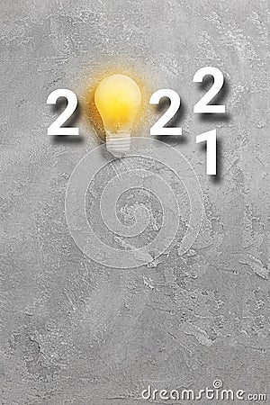 Yelow light bulb with 2022 new year text on grey background Stock Photo