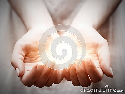 The light in young woman hands. Sharing, giving, offering, protection Stock Photo