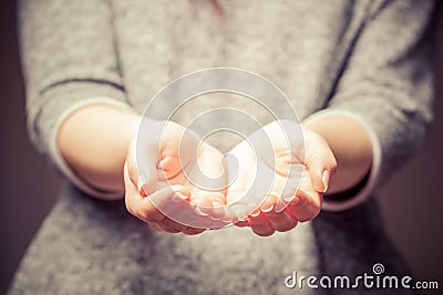 Light in young woman's hands. Sharing, giving, offering, taking care, protection. Stock Photo