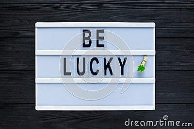 Lightbox with title Be lucky on black wooden background. Creative background to St. Patricks Stock Photo