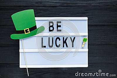 Lightbox with title Be lucky and photobooth green hat on wooden sticks at green background. Creative background to St. Patricks Stock Photo