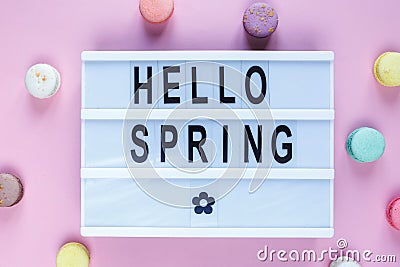 Lightbox with title Hello spring and macaroons on pink background. Decoration, spring background. Top view Stock Photo