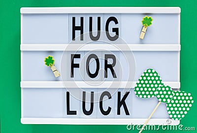 Lightbox with title Hug for luck on green background. Creative background to St. Patricks Day. Flat lay composition Stock Photo