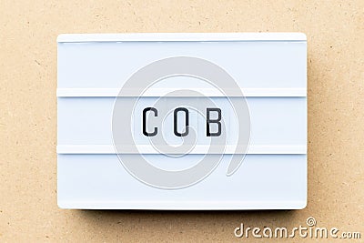 Light box with word COB abbreviation of close of business on wood background Stock Photo