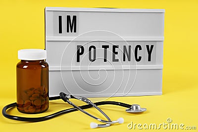 Lightbox with word IMPOTENCY jar of pills and stethoscope on yellow background Stock Photo