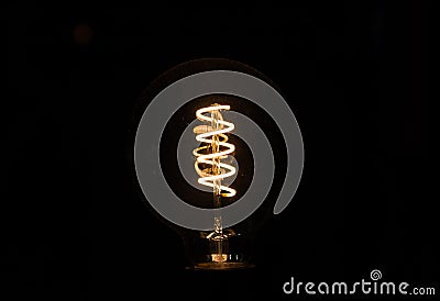 Lightbulb on dark background with bright spiral wire Stock Photo