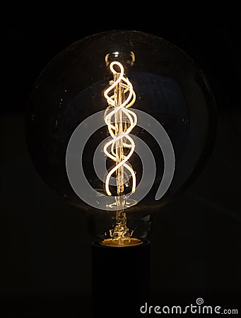 Lightbulb on dark background with bright spiral wire Stock Photo