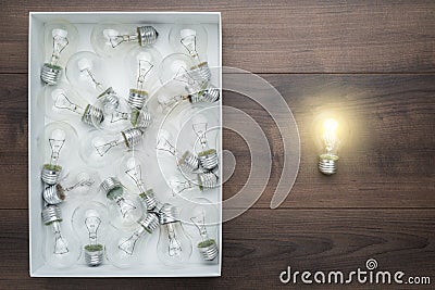 Lightbulb glowing outside the box as thinking out of the box concept Stock Photo