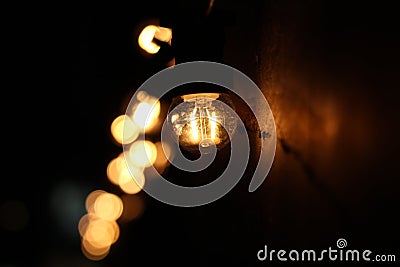 Lightbulbs Glowing Orange on a Wooden Wall Stock Photo