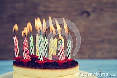 Lighted birthday candles on a cheesecake, with a retro effect Stock Photo