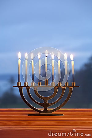 Lighted candles burning in traditional Jewish menorah for Jewish Hanukkah chanukkiah holiday with blue background Stock Photo