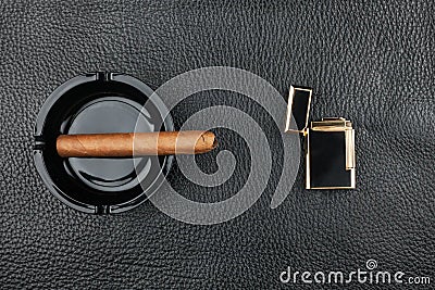 Lighter and black ashtray with cigar Stock Photo