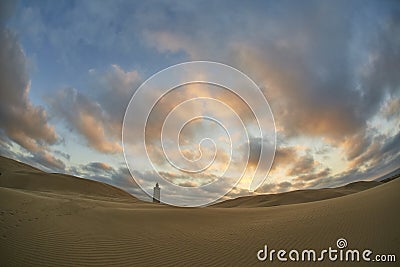 Lighthouse on beach with pretty sunset Stock Photo