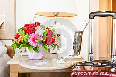 Lighthouse candle holder with champagne bottle, siutcase and flower basket in the upscale hotel room. Being alone Stock Photo