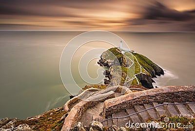 Lighthouse on coastal island with horizon and beautiful sunset Stock Photo
