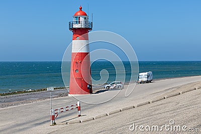 Lighthouse at dike with recreating people near Westkapelle, the Netherlands Editorial Stock Photo