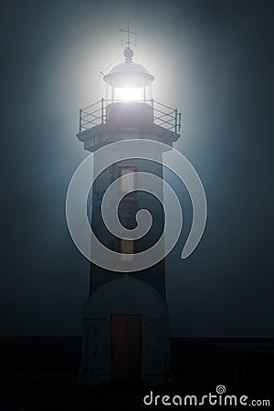 Lighthouse in a foggy night Stock Photo