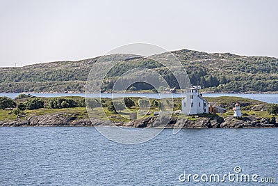 Lighthouse and house on green cliff, near Bronnoysund, Norway Stock Photo