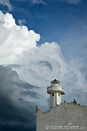 A lighthouse on an old building in Telchac Puerto on the coast of YucatÃ¡n on the Gulf of Mexico, cormorants sitting on the roof Stock Photo