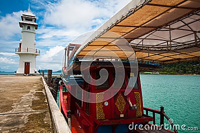 Lighthouse and a passage red boat Stock Photo