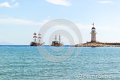 Lighthouse and sail ships in the Mediterranean sea Stock Photo