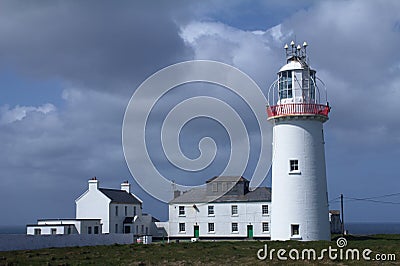 Lighthouse and sky on the irish coast Stock Photo