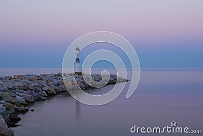 Lighthouse at Sunrise on the Rocky Coast Stock Photo