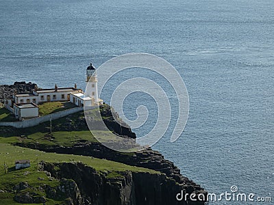 Lighthouse on top of a green cliff Stock Photo