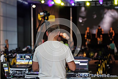 Lighting and Sound Technician and Broadcast Operator at Work in the BackStage during a Public Event Editorial Stock Photo