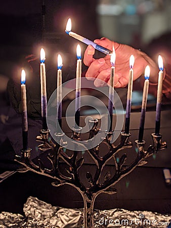 Lighting up a menorah on Hannukah Stock Photo