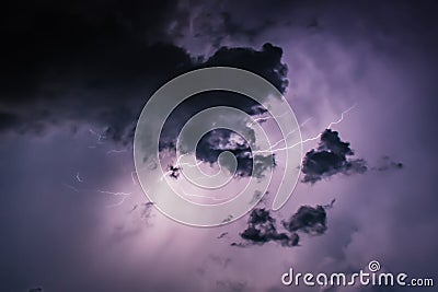 Lightning Bolt Discharges in Purple Storm Clouds at Night Close Stock Photo