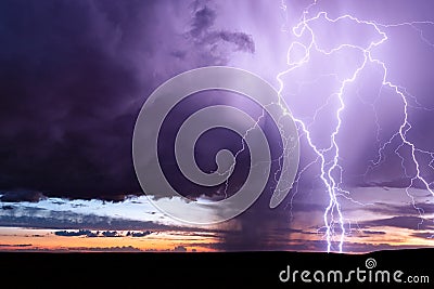 Lightning strike from a powerful storm at sunset. Stock Photo