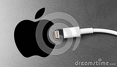 Lightning cabel with Apple logo on Apple device. Editorial Stock Photo