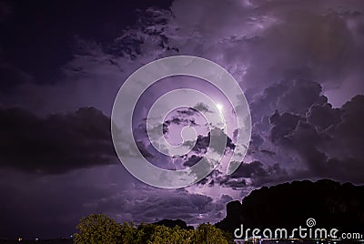 Lightning in the clouds on the sky at night Background sea and mountains Stock Photo