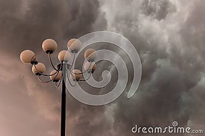 Lightning flashes stormy clouds over big, glorious street lamp Stock Photo