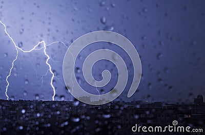 Lightning in the night sky strikes the roof of the house Stock Photo