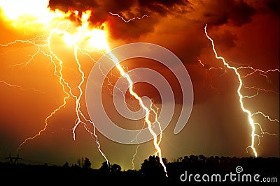 Lightning strike on the dark cloudy sky. Orange, yellow and red toned image Stock Photo