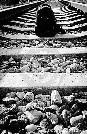 Lightweight hiking black backpack, standing alone on the railway track. Silver Plated Photo Stock Photo