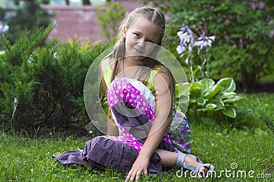 Liitle girl sitting on the grass Stock Photo