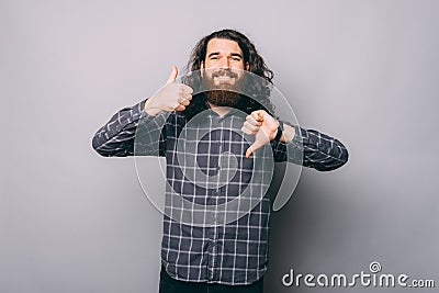 Like or dislike, Photo of young man with beard and long hair showing agree or disagree gesture Stock Photo