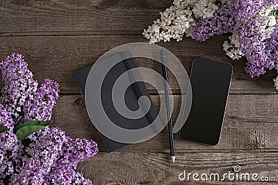 Lilac blossom on rustic wooden background with notebook for greeting message. Top view Stock Photo