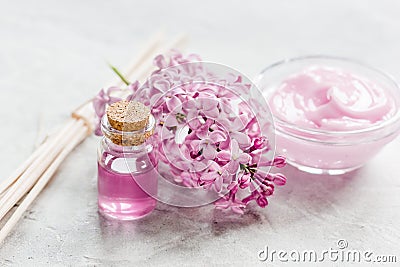 Lilac cosmetics with flowers and spa set on stone table background Stock Photo