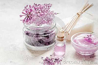 Lilac cosmetics with flowers and spa set on stone table background Stock Photo