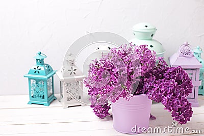 Lilac flowers and brigh lanterns on white wooden background aga Stock Photo
